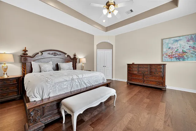 a bedroom with a bed a chandelier and a dresser