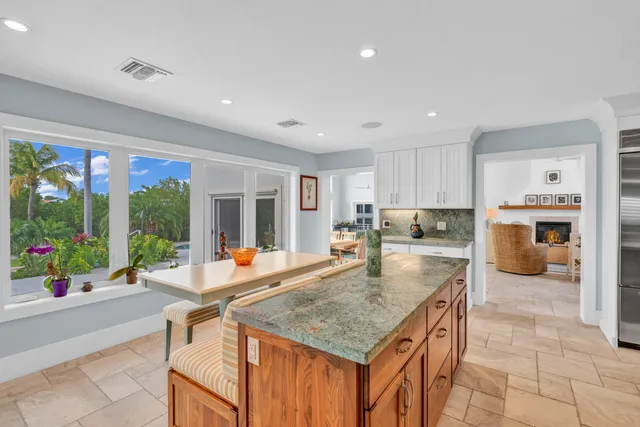 a kitchen with stainless steel appliances granite countertop kitchen island a table and chairs in it