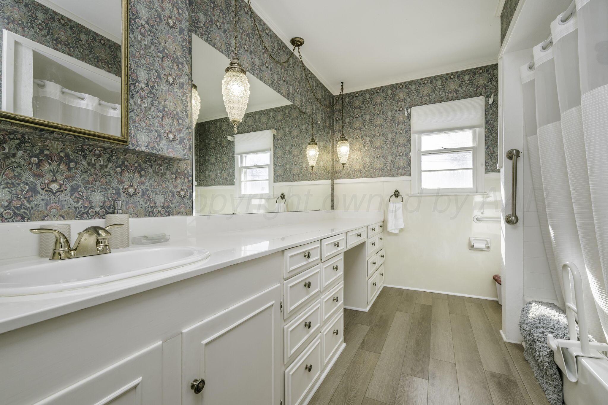 3228 South Travis Street Amarillo, TX 79109 - Photo 14 of 22 a bathroom with a double vanity sink a mirror and a shower