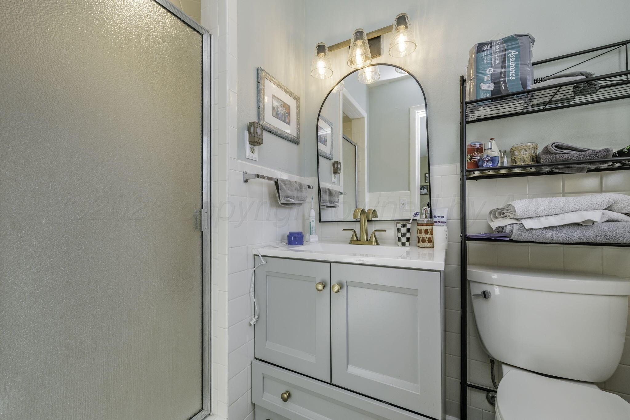 3228 South Travis Street Amarillo, TX 79109 - Photo 18 of 22 a bathroom with a toilet sink and mirror
