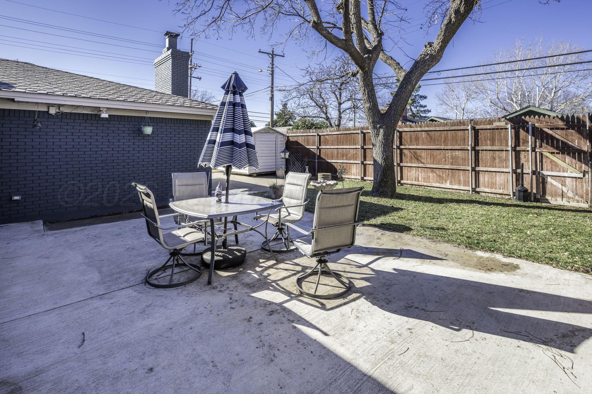 3228 South Travis Street Amarillo, TX 79109 - Photo 19 of 22 a view of a backyard with table and chairs and a barbeque