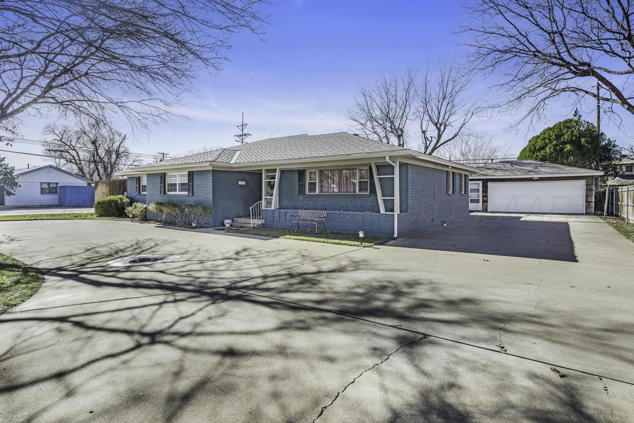 3228 South Travis Street Amarillo, TX 79109 - Photo 2 of 22 a front view of a house with a yard and large tree