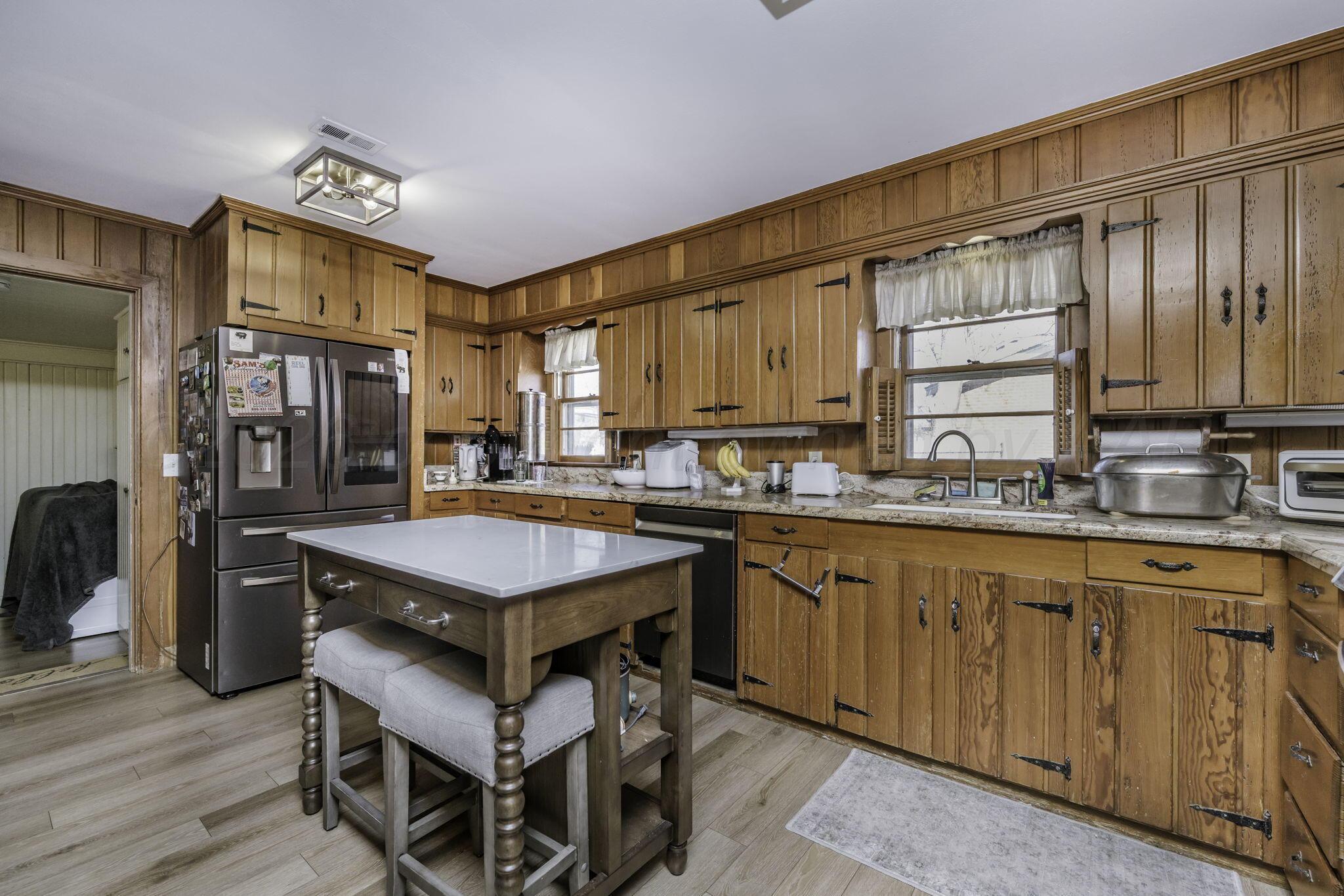 3228 South Travis Street Amarillo, TX 79109 - Photo 6 of 22 a kitchen with stainless steel appliances granite countertop a stove a sink dishwasher and a refrigerator