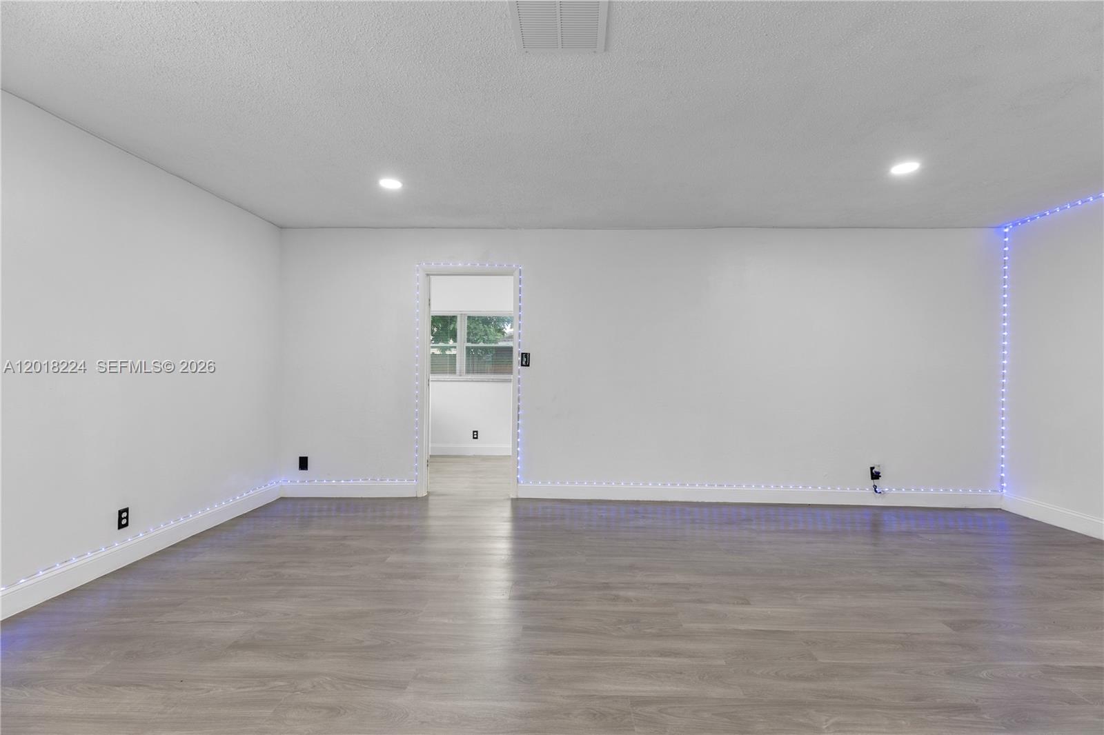 7958 Southwest 6th Street Pompano Beach, FL 33068 - Photo 7 of 57 an empty room with wooden floor and windows
