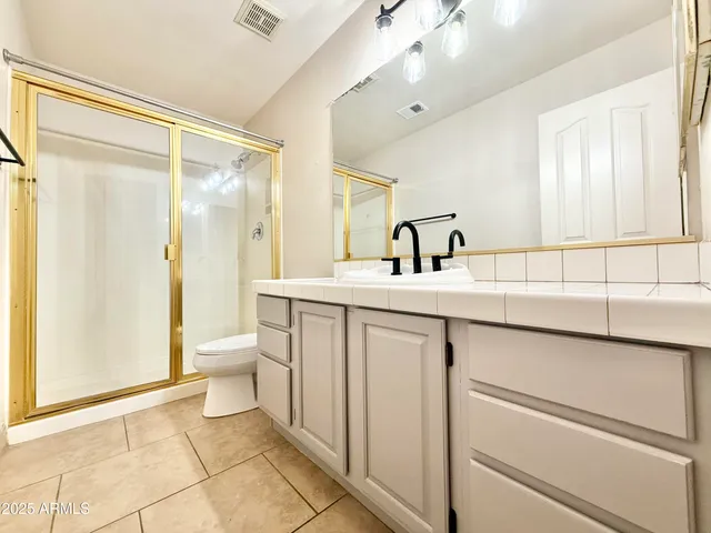 a bathroom with a granite countertop sink and a large mirror