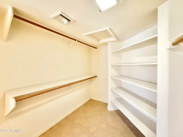 a view of walk in closet with empty racks