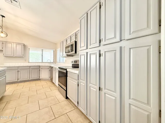a large white kitchen with cabinets and stainless steel appliances