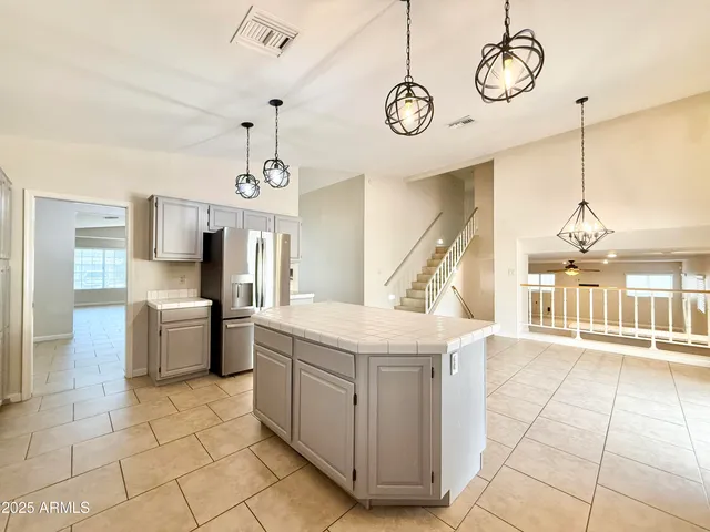 a view of a kitchen with kitchen island stainless steel appliances cabinets a sink and a counter top