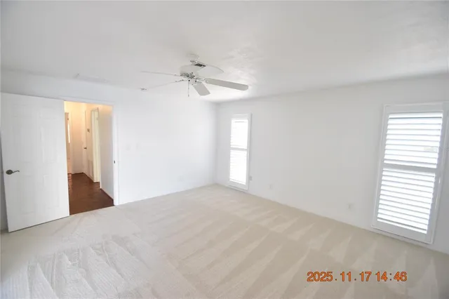 an empty room with windows and fan