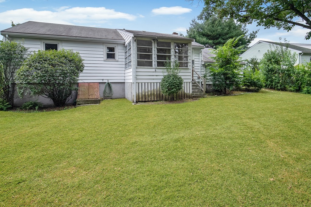 10 Wadsworth Road Arlington, MA 02476 - Photo 11 of 12 front view of a house with a yard and potted plants