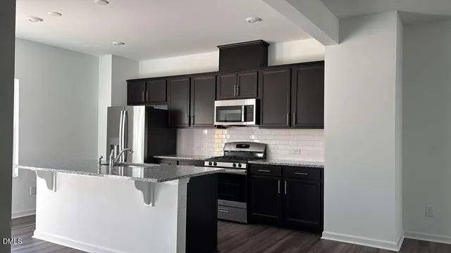 a kitchen with stainless steel appliances a refrigerator stove microwave and sink