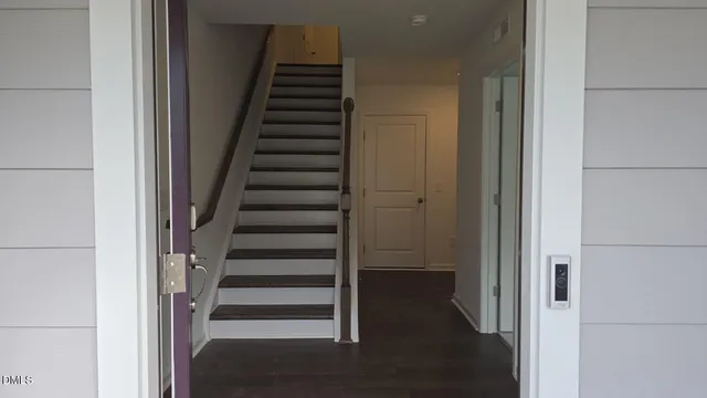 a view of a hallway with wooden floor and entryway