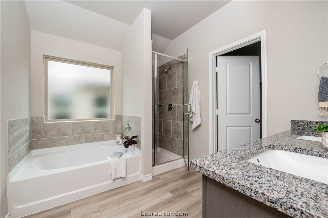 2159 Chief Street Bryan, TX 77807 - Photo 17 of 22 a bathroom with a granite countertop tub sink and shower
