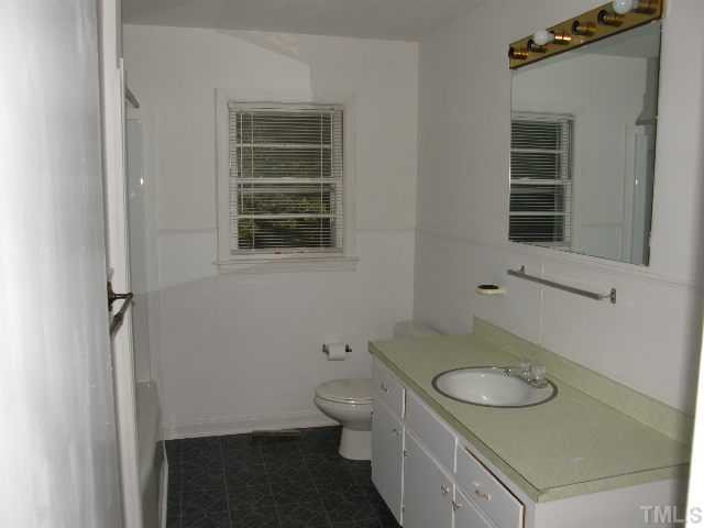 653 Sunnybrook Road Raleigh, NC 27610 - Photo 4 of 14 a bathroom with a granite countertop toilet and a sink