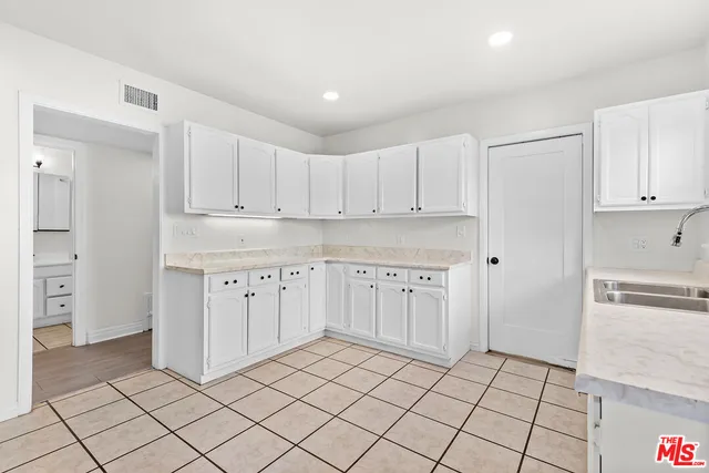 a kitchen with granite countertop white cabinets and stainless steel appliances