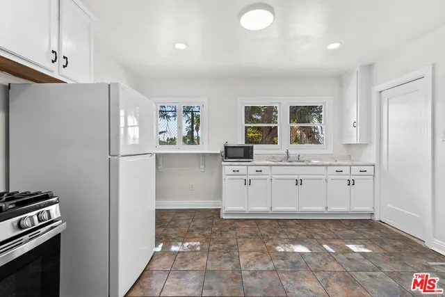 a kitchen with a refrigerator sink and cabinets