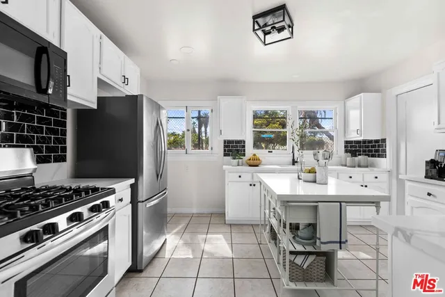 a kitchen with stainless steel appliances a stove a sink and a refrigerator