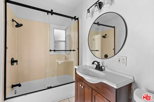 a bathroom with a sink a mirror a vanity and shower