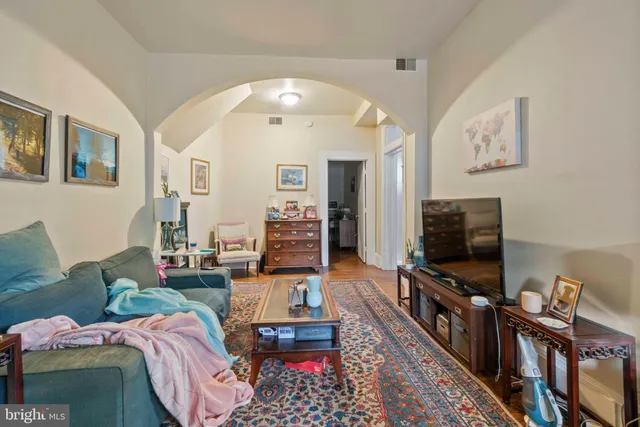 a living room with furniture and a baby crib