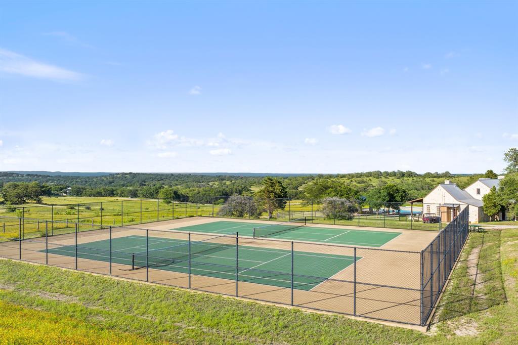 207 Verbena Road Johnson City, TX 78636 - Photo 31 of 40 Two fenced tennis courts await with scenic hillside views surrounding the property.