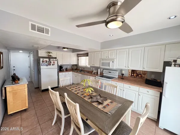 a kitchen with a dining table chairs refrigerator and cabinets