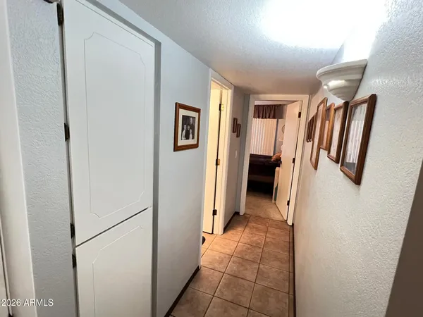 a view of a hallway with closet and bathroom