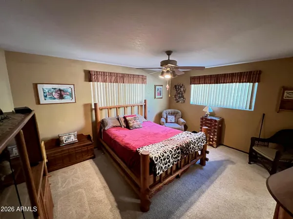 a bedroom with a bed a dresser and chair