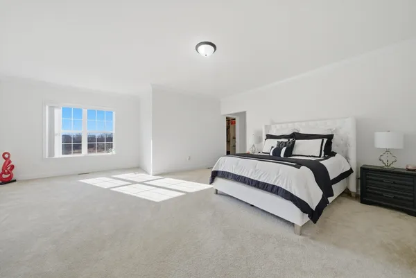 a spacious bedroom with a bed and a window