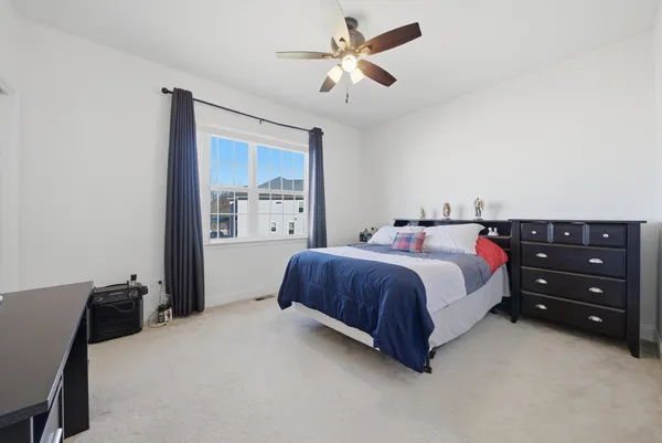 a spacious bedroom with a bed and a chandelier