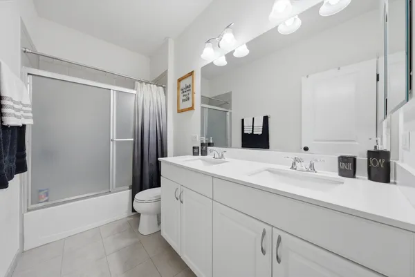 a bathroom with a double vanity sink mirror and toilet