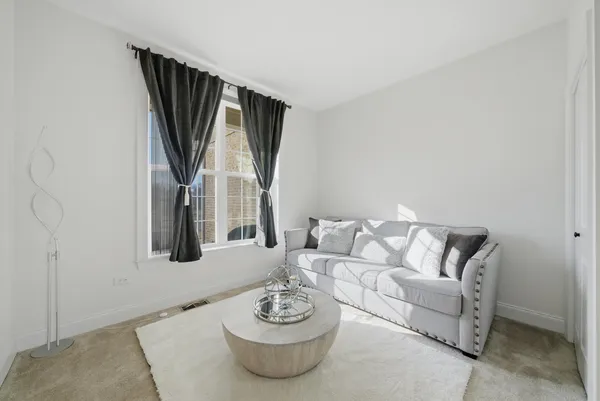 a living room with furniture and a white wall painting