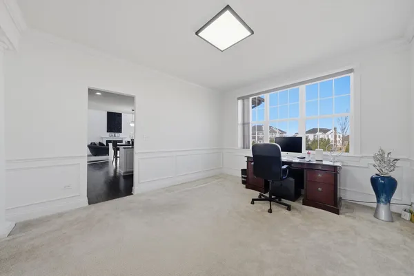 a view of a workspace with furniture and a window