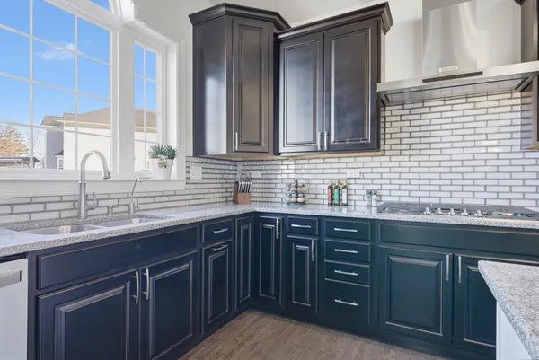 a bathroom with a granite countertop sink two mirror and a window