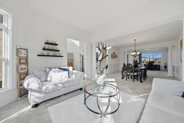 a living room with furniture kitchen and a chandelier