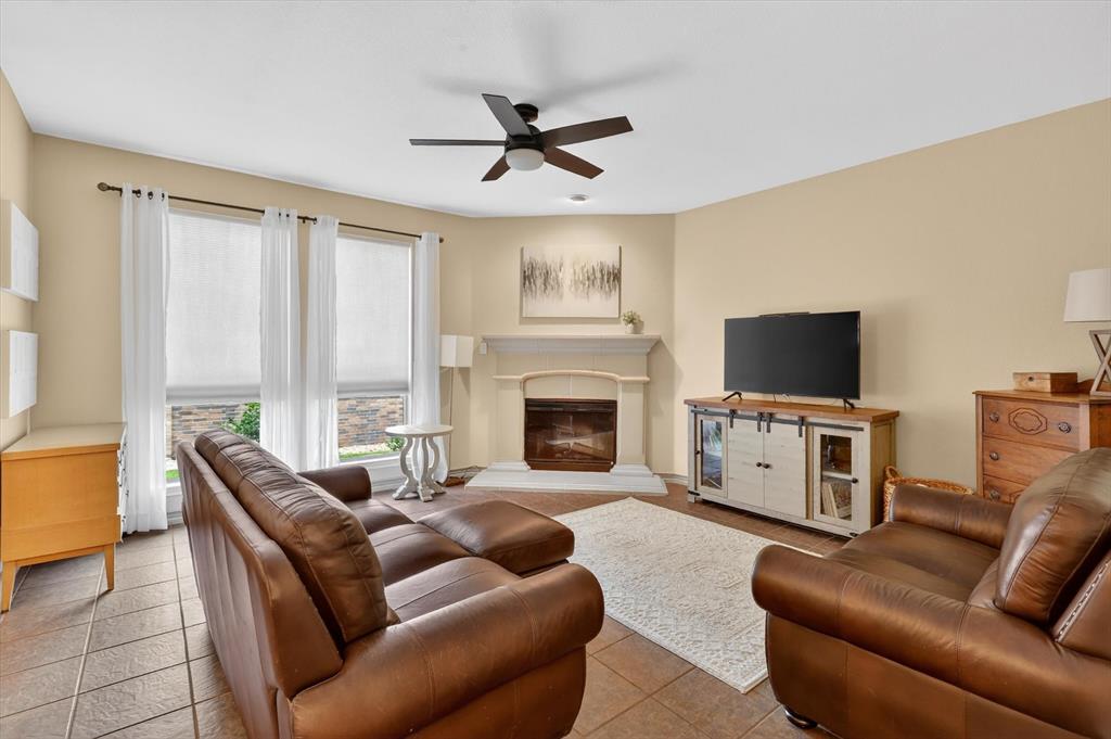 808 Mexicali Way Haslet, TX 76052 - Photo 12 of 25 Living area with ceiling fan and a glass covered fireplace