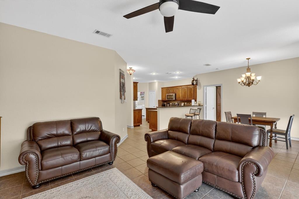 808 Mexicali Way Haslet, TX 76052 - Photo 13 of 25 Living room with a ceiling fan, a chandelier, and light tile patterned floors