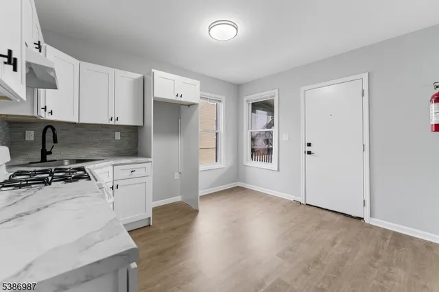an empty room with wooden floor and cabinets