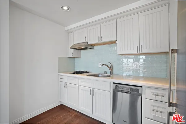 a kitchen with granite countertop white cabinets and stainless steel appliances