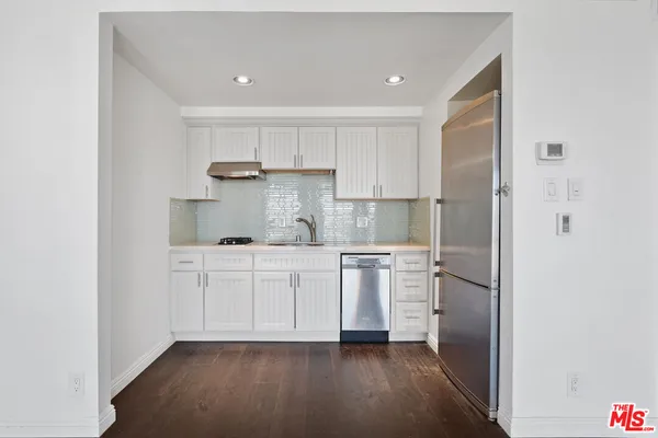 a view of a kitchen with wooden floor and a kitchen