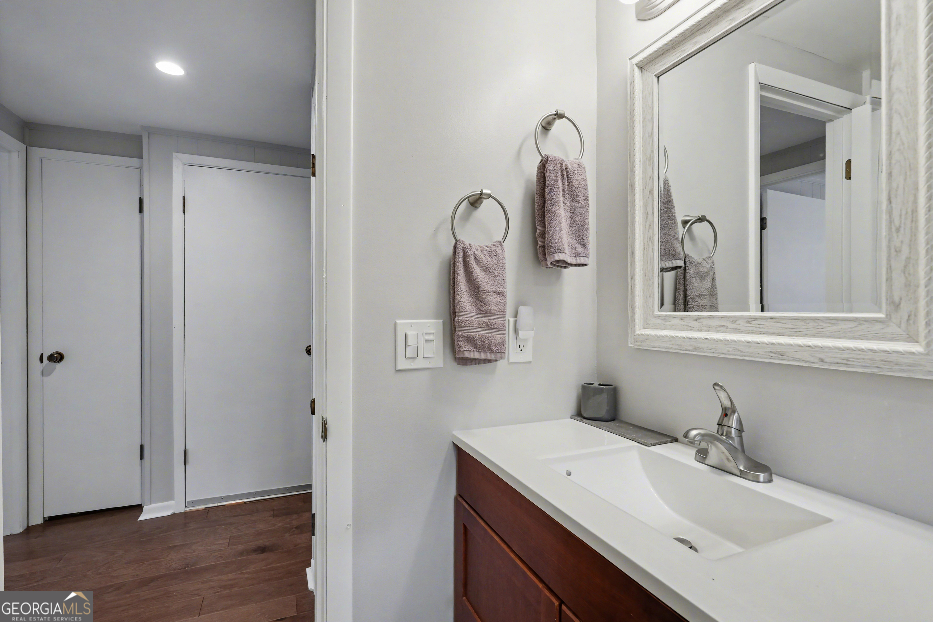 559 Maple Leaf Drive Dillard, GA 30537 - Photo 17 of 49 a bathroom with a sink and mirror with wooden floor