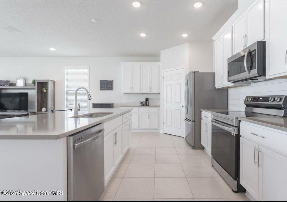 2792 Pinwherry Street Palm Bay, FL 32907 - Photo 11 of 19 a kitchen with stainless steel appliances granite countertop a refrigerator stove microwave and sink