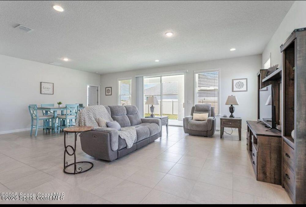2792 Pinwherry Street Palm Bay, FL 32907 - Photo 12 of 19 a living room with furniture large window and a flat screen tv