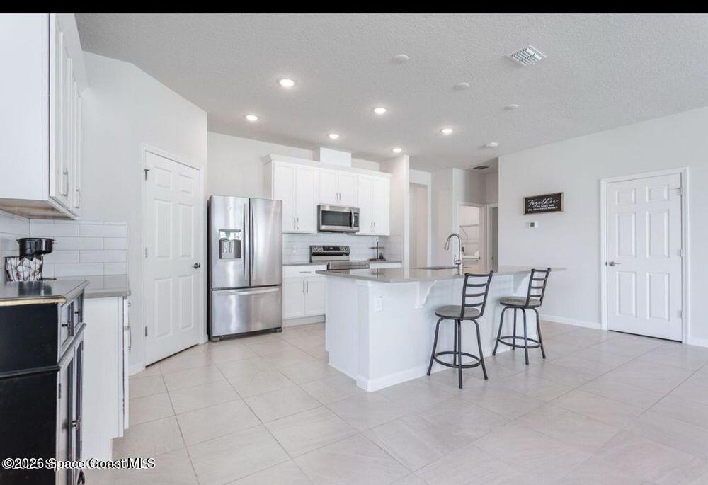 2792 Pinwherry Street Palm Bay, FL 32907 - Photo 5 of 19 a kitchen with a refrigerator and a table