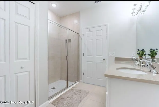 a bathroom with a shower sink and mirror