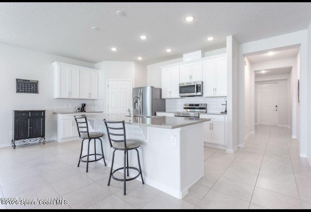 2792 Pinwherry Street Palm Bay, FL 32907 - Photo 10 of 19 a kitchen with kitchen island granite countertop a stove a sink and a refrigerator