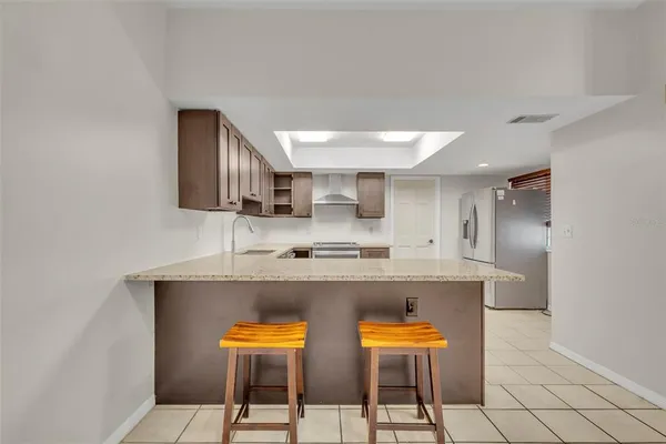 a kitchen with stainless steel appliances kitchen island granite countertop a sink and chairs