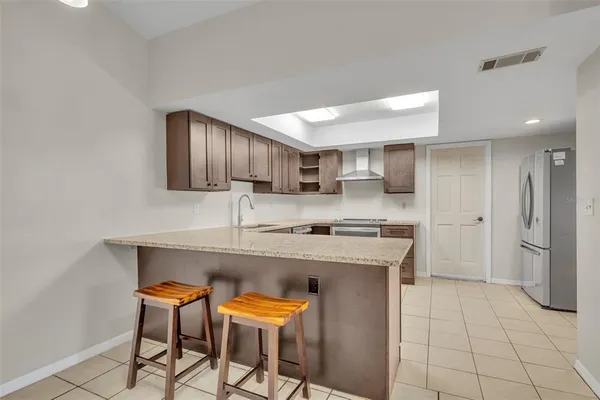 a kitchen with stainless steel appliances granite countertop a sink and a refrigerator