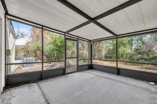 a view of an empty room with wooden floor and a balcony