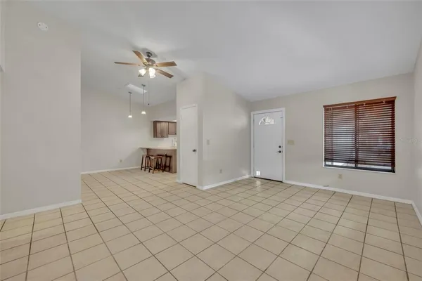 a view of an empty room and a chandelier fan