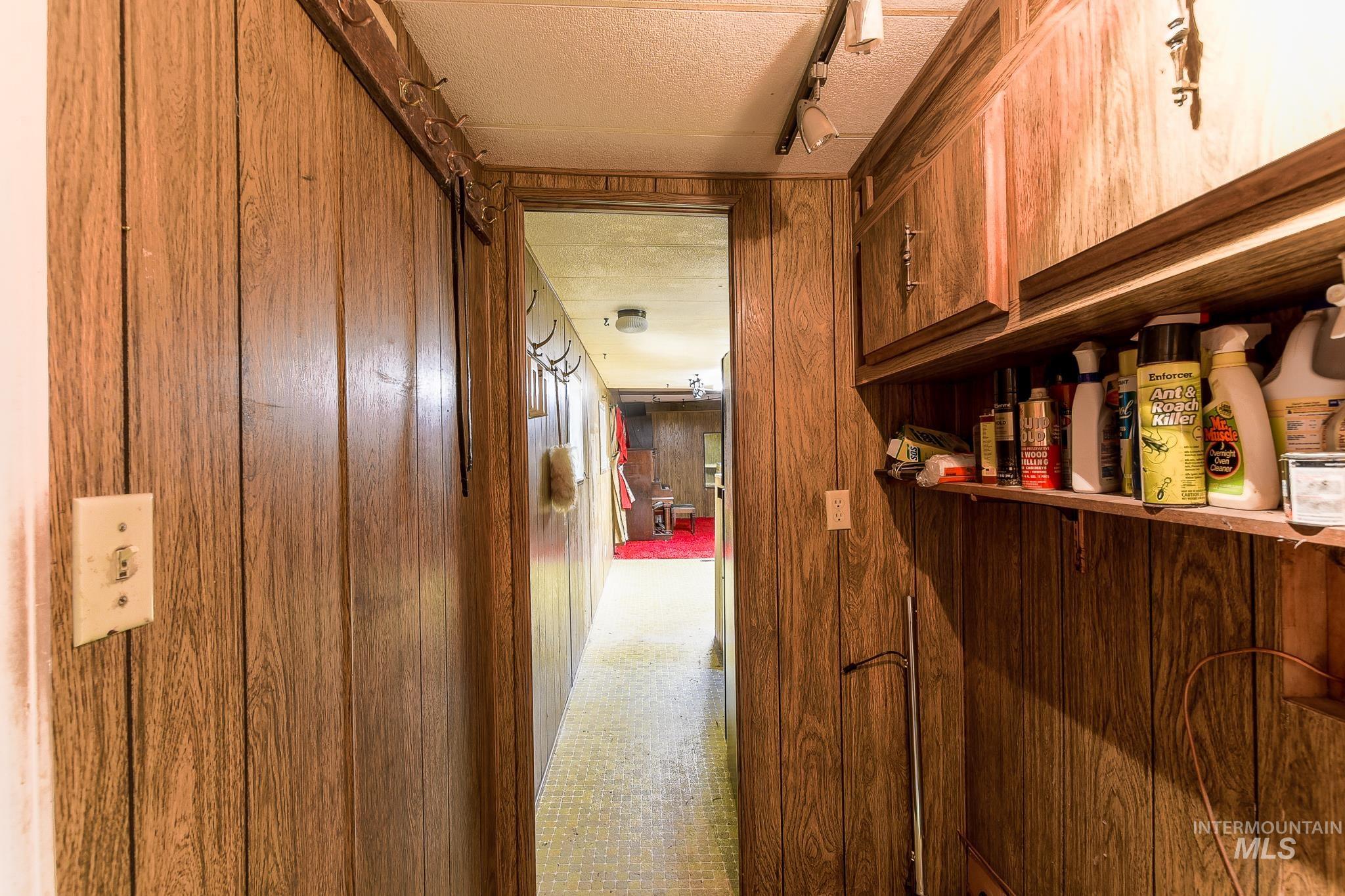 1206 Idlers Rest Road Moscow, ID 83843 - Photo 21 of 47 Wood-panel walls define this hallway, featuring a built-in storage shelf and overhead cabinetry